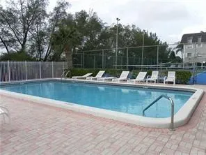 a view of a swimming pool with a yard and sitting area