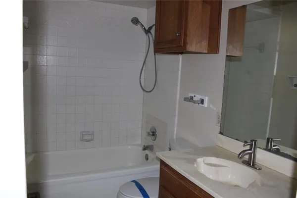 a bathroom with a granite countertop sink a toilet and shower