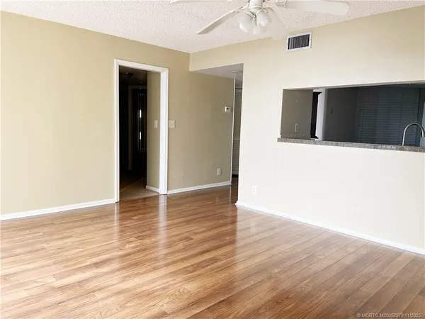 a view of an empty room with wooden floor