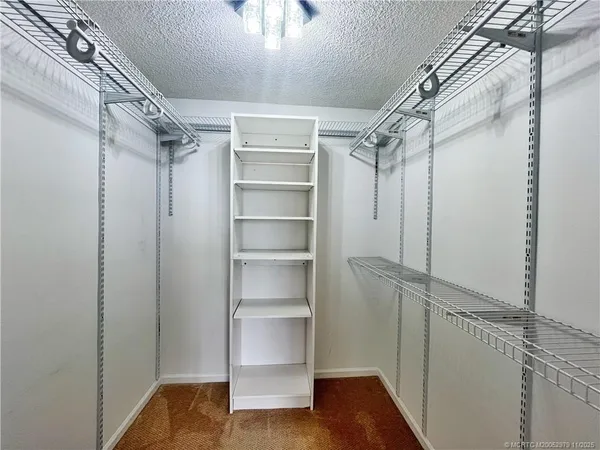 a view of walk in closet with empty racks