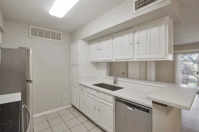 a kitchen with white cabinets and stainless steel appliances