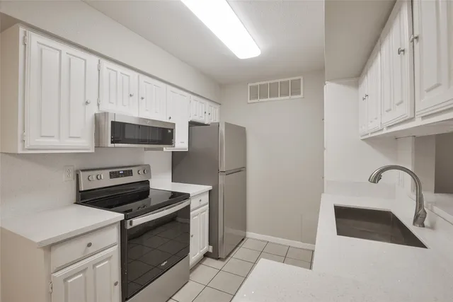 a kitchen with a sink appliances and cabinets