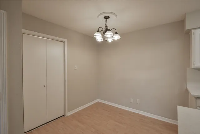 a kitchen with stainless steel appliances granite countertop a sink a stove a refrigerator with white cabinets and wooden floor