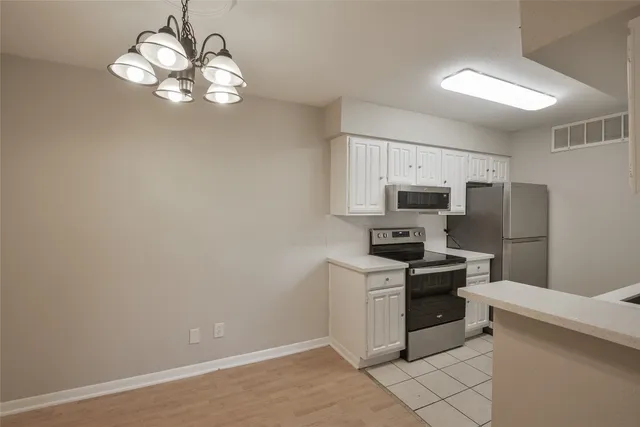 a kitchen with a stove and a white cabinets