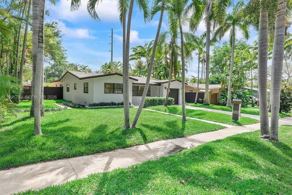 a view of a house with a backyard and a tree
