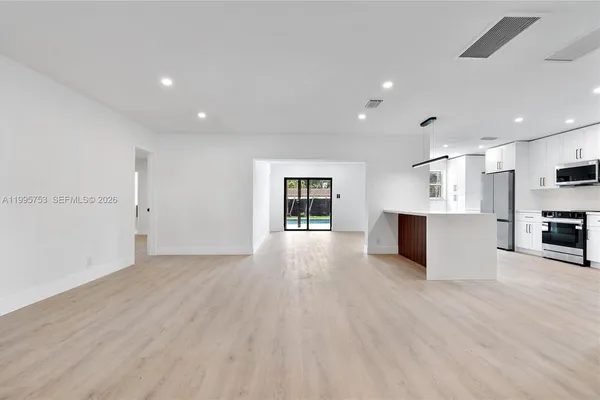 a view of kitchen with stove and cabinets