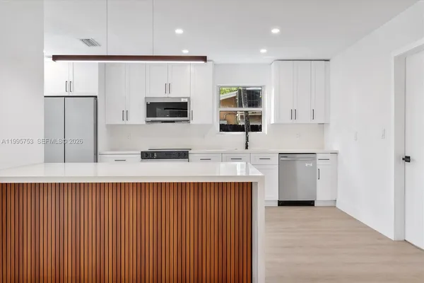 a kitchen with stainless steel appliances a sink and a refrigerator
