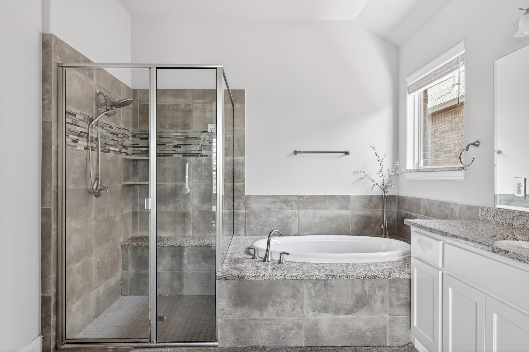 4105 Haight Street Round Rock, TX 78681 - Photo 22 of 40 Spacious bathroom featuring a glass-enclosed shower with dual shower heads, integrated bench, and tiled walls with decorative mosaic accents