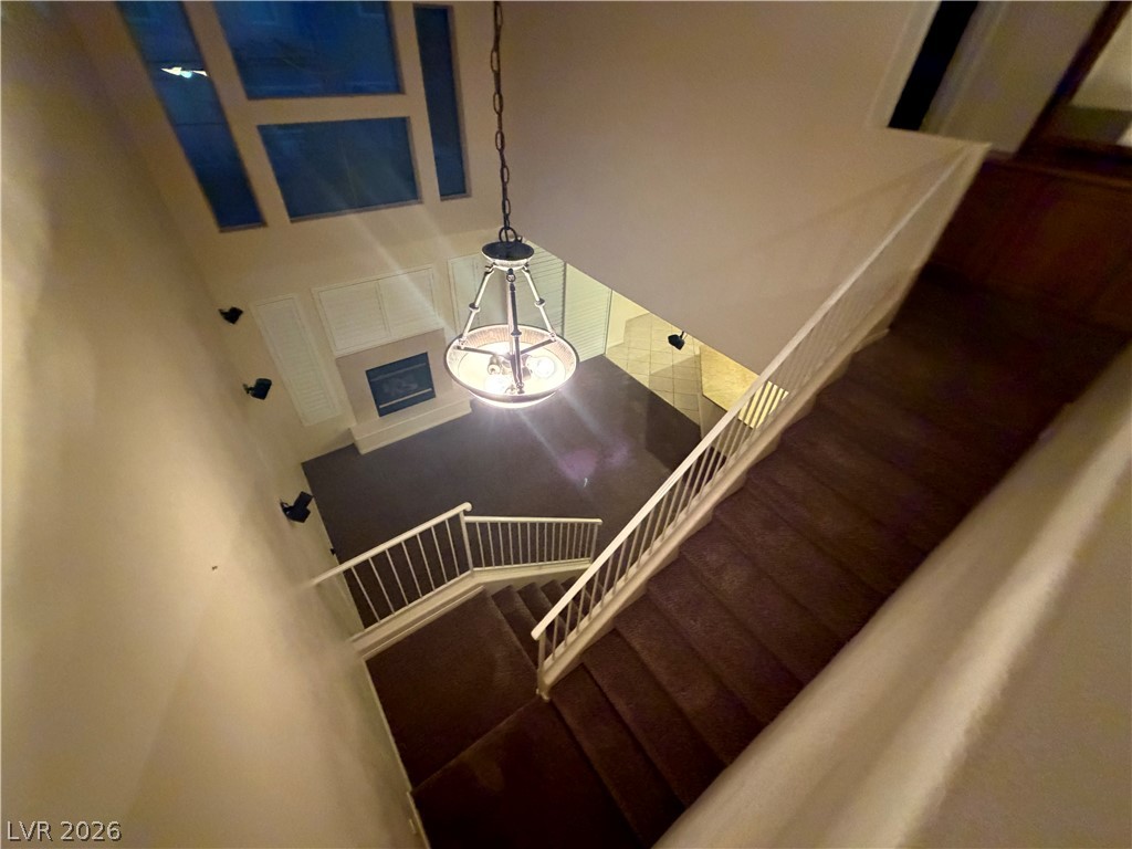 7629 Rory Court Las Vegas, NV 89129 - Photo 15 of 25 A grand two-story living area features a stately fireplace and striking upper-level windows, creating an airy ambiance.
