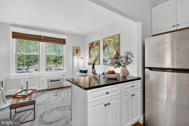 a kitchen with white cabinets and a window