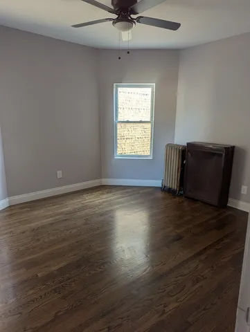 a view of room with window hardwood floor and a ceiling fan