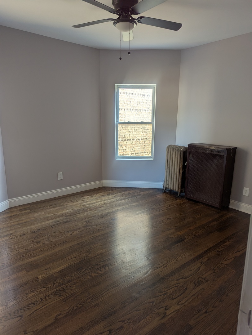 7936 South Champlain Avenue, Unit 1 Chicago, IL 60619 - Photo 6 of 8 a view of room with window hardwood floor and a ceiling fan