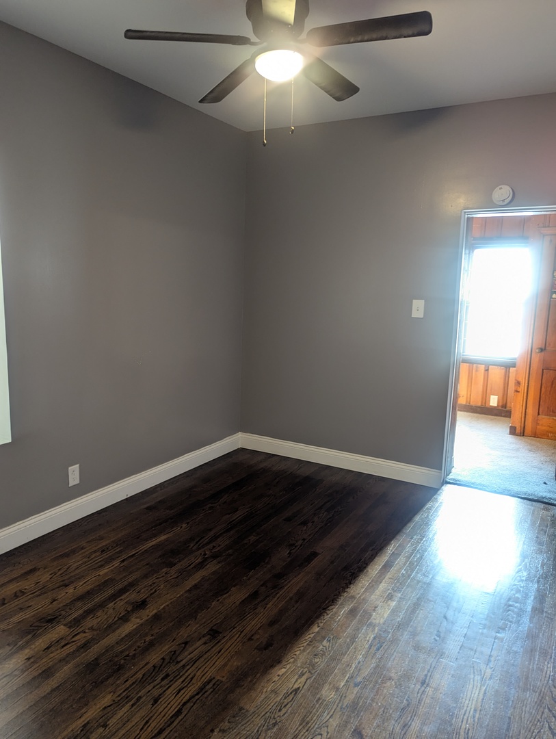 7936 South Champlain Avenue, Unit 1 Chicago, IL 60619 - Photo 8 of 8 a view of a livingroom with wooden floor and a ceiling fan