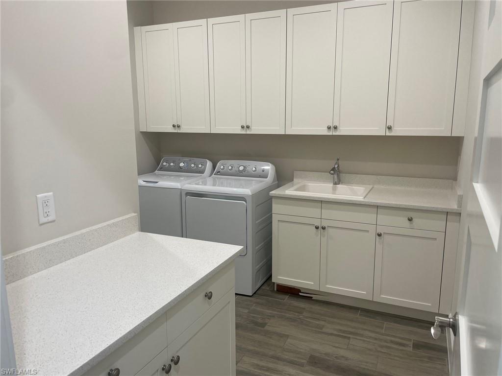 5685 Highbourne Drive Naples, FL 34113 - Photo 14 of 26 a utility room with cabinets washer and dryer