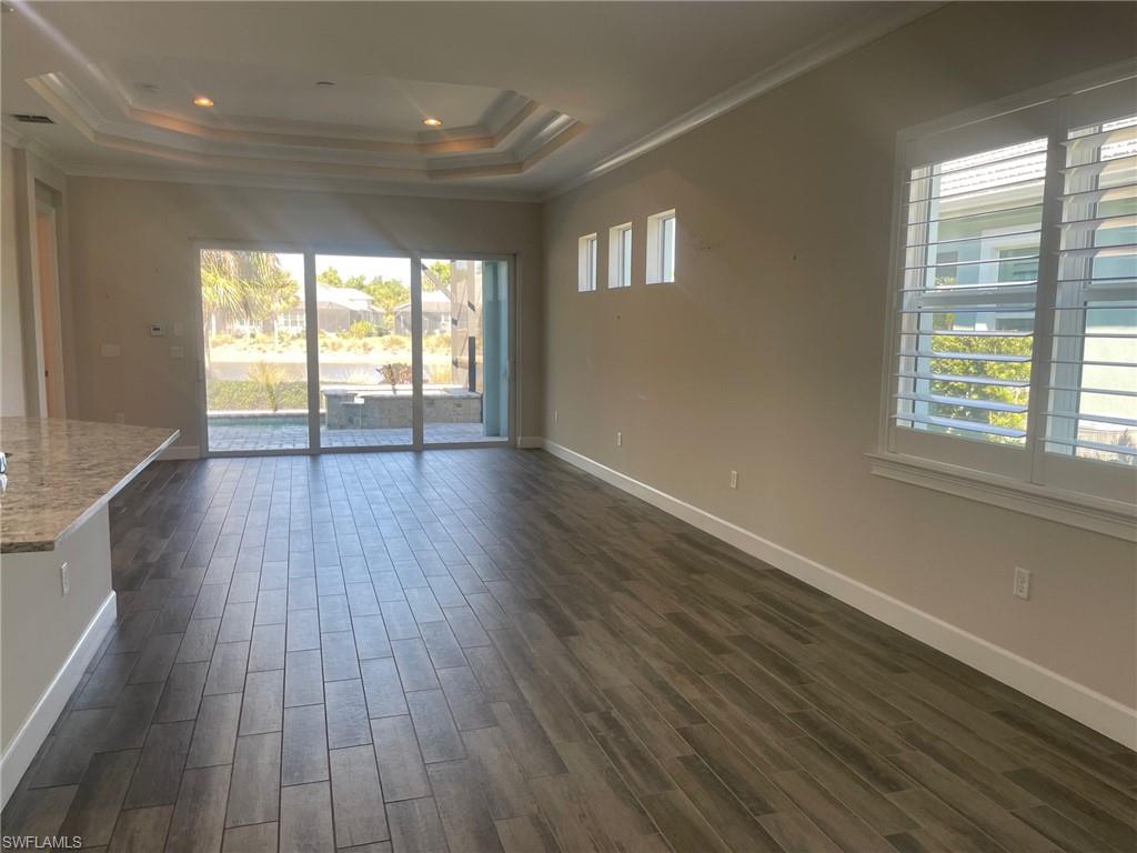 5685 Highbourne Drive Naples, FL 34113 - Photo 16 of 26 a view of an empty room with wooden floor and a window
