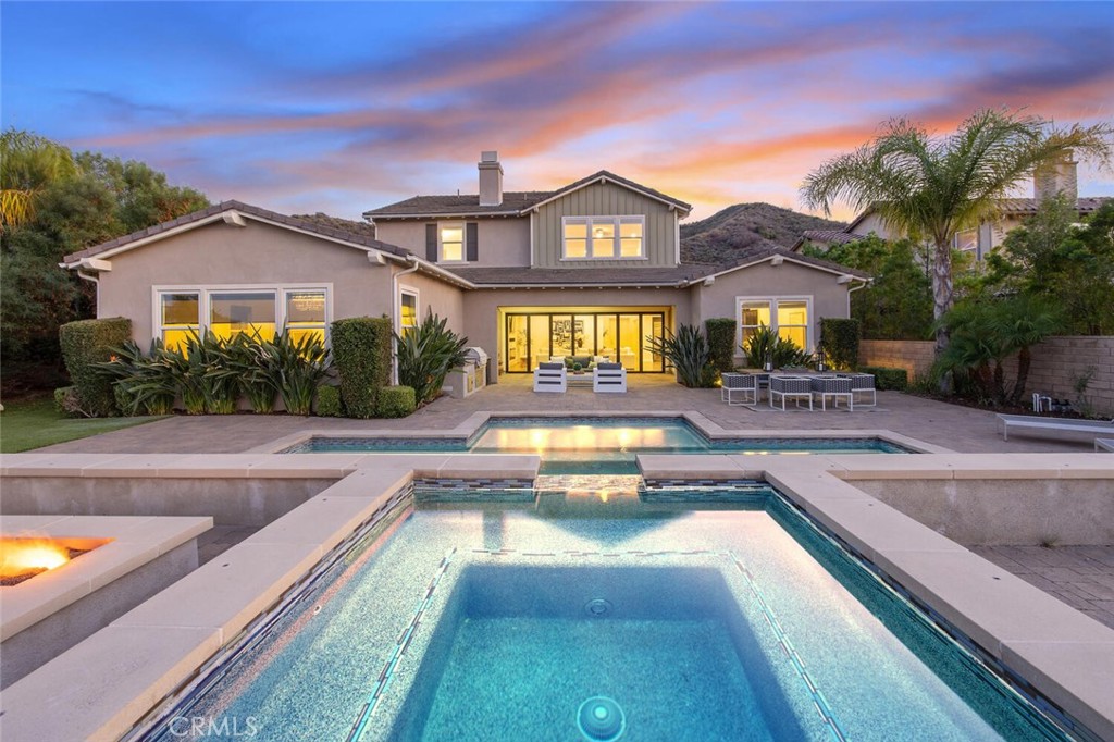 a view of a house with swimming pool and a chairs in a patio