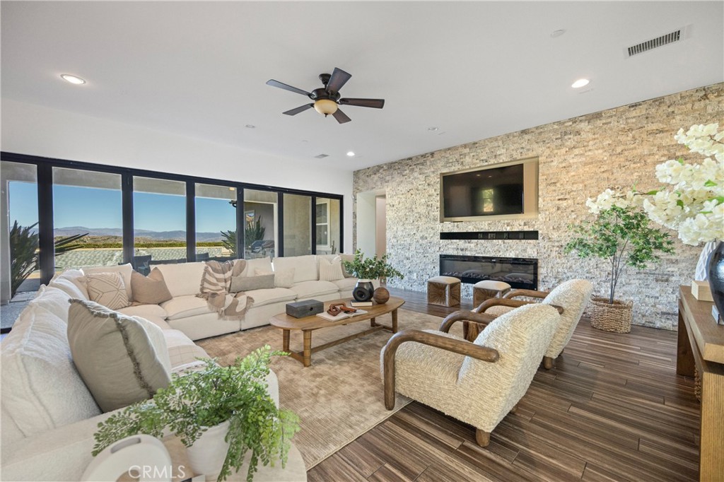 24910 Old Stone Way Stevenson Ranch, CA 91381 - Photo 13 of 67 a living room with furniture a flat screen tv and a fireplace