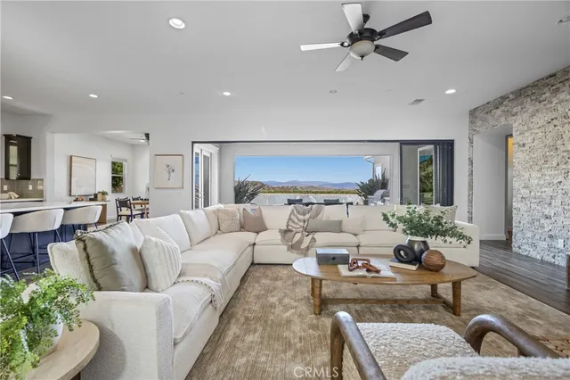 a living room with furniture kitchen view and a large window