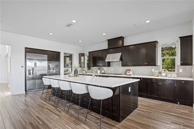 a kitchen with stainless steel appliances granite countertop a sink a stove and refrigerator