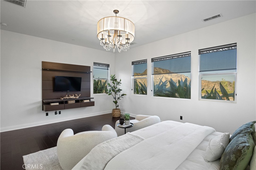 24910 Old Stone Way Stevenson Ranch, CA 91381 - Photo 29 of 67 a living room with furniture a chandelier and a flat screen tv