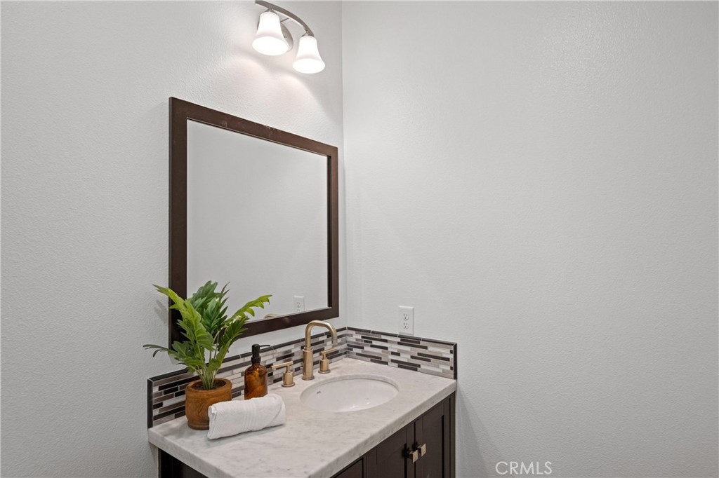 24910 Old Stone Way Stevenson Ranch, CA 91381 - Photo 34 of 67 a bathroom with a sink a mirror and a potted plant