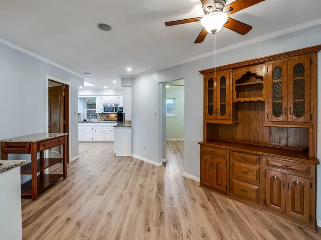 a white house that has tree in front of it