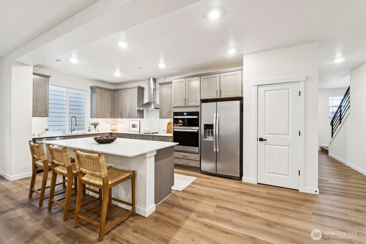 24233 13 Avenue Southeast, Unit CR26 Bothell, WA 98021 - Photo 6 of 21 a kitchen with kitchen island a refrigerator stove microwave and cabinets