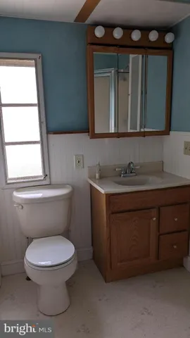 a bathroom with a toilet sink and mirror