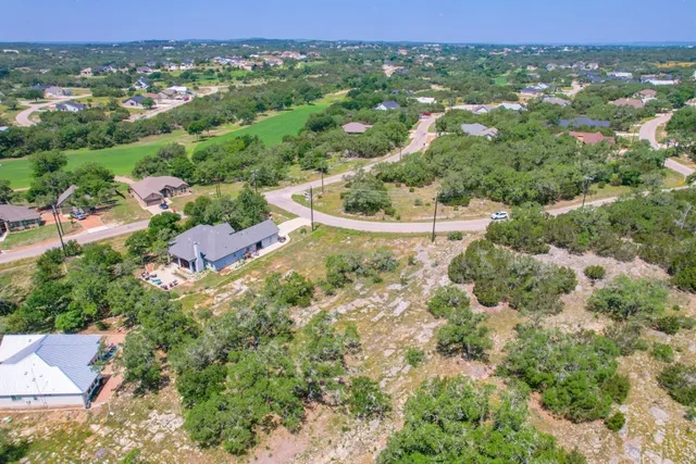an aerial view of a house with a yard and lake view