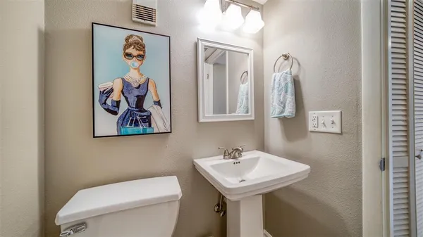 a bathroom with a toilet a sink and mirror