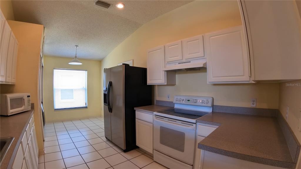 12633 Early Run Lane Riverview, FL 33578 - Photo 19 of 44 a kitchen with stainless steel appliances granite countertop a refrigerator a stove and a sink
