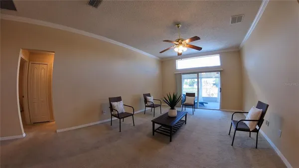 a living room with furniture a chandelier and a window