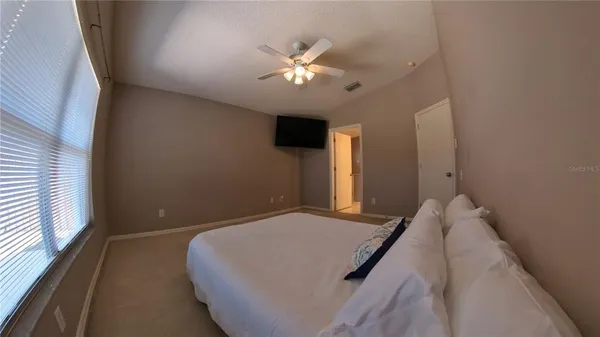 a bedroom with a bed and a ceiling fan