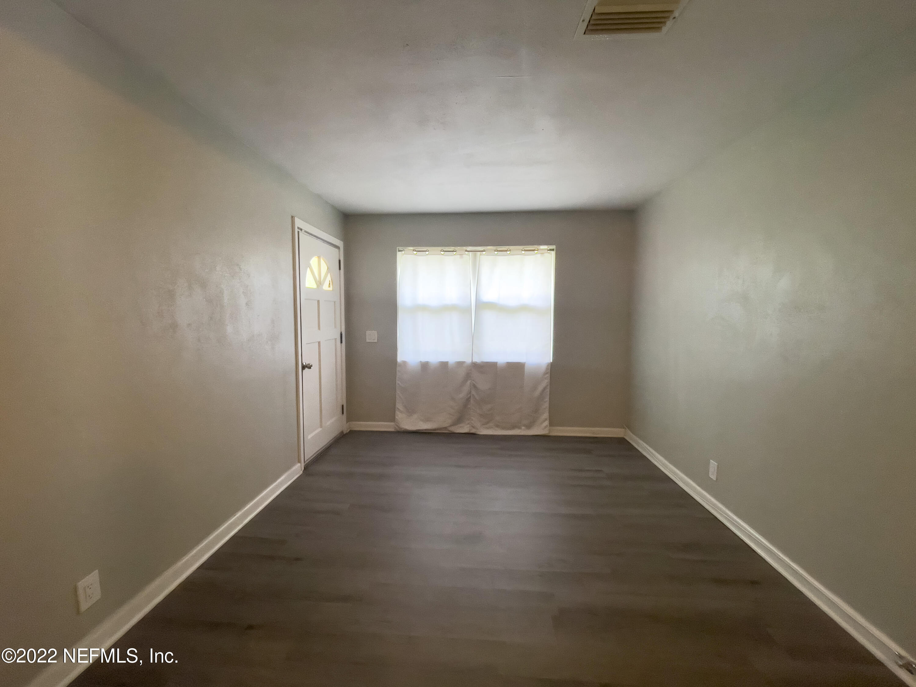 3151 Brasque Drive Jacksonville, FL 32209 - Photo 9 of 18 an empty room with wooden floor and windows