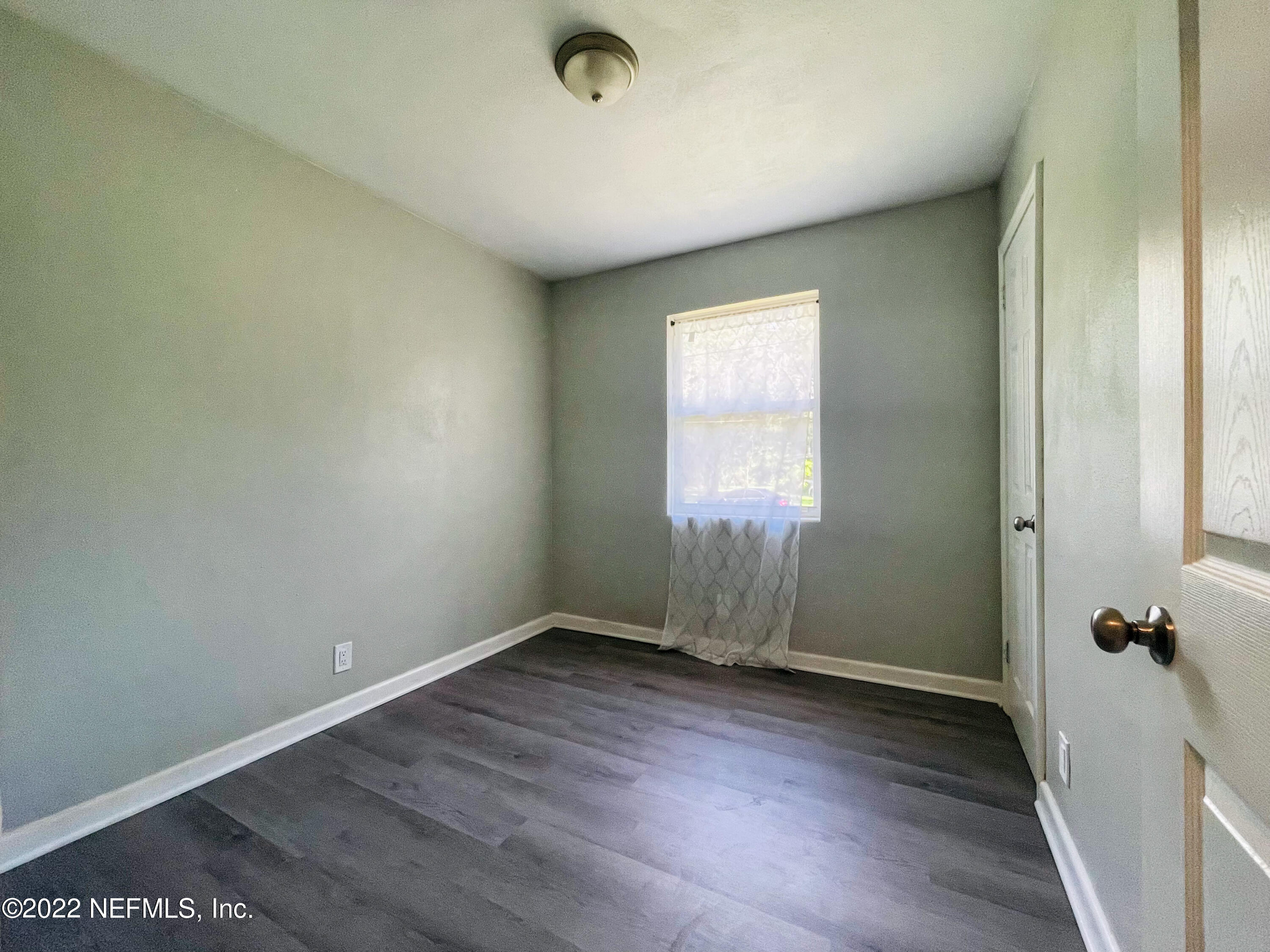 3151 Brasque Drive Jacksonville, FL 32209 - Photo 10 of 18 an empty room with wooden floor and windows