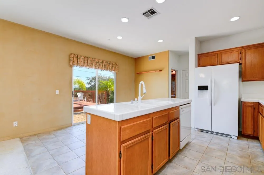 344 Natalie Way Fallbrook, CA 92028 - Photo 12 of 37 a kitchen with a sink a refrigerator and a stove top oven