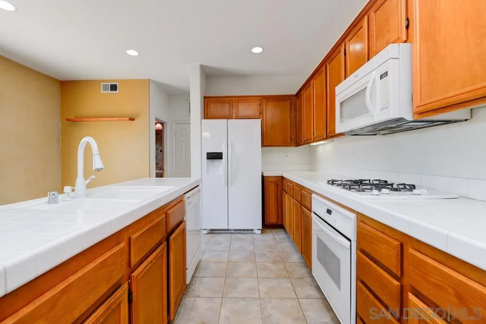 344 Natalie Way Fallbrook, CA 92028 - Photo 13 of 37 a kitchen with stainless steel appliances granite countertop a sink and a refrigerator