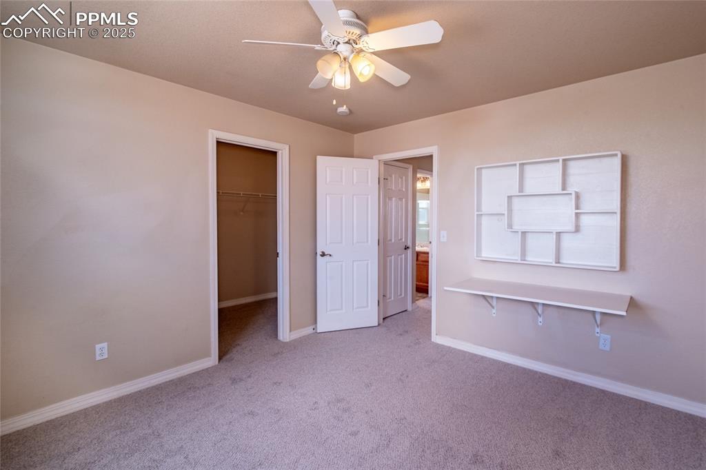 7313 Owings Point Peyton, CO 80831 - Photo 22 of 47 Unfurnished bedroom featuring light carpet, a walk in closet, and ceiling fan