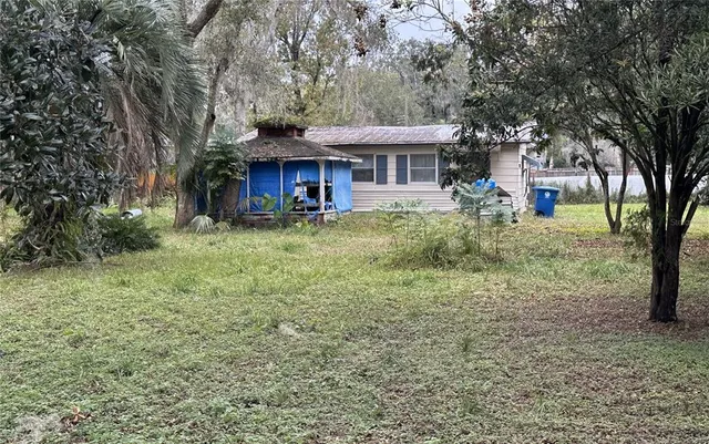 a view of a house with a yard and sitting area
