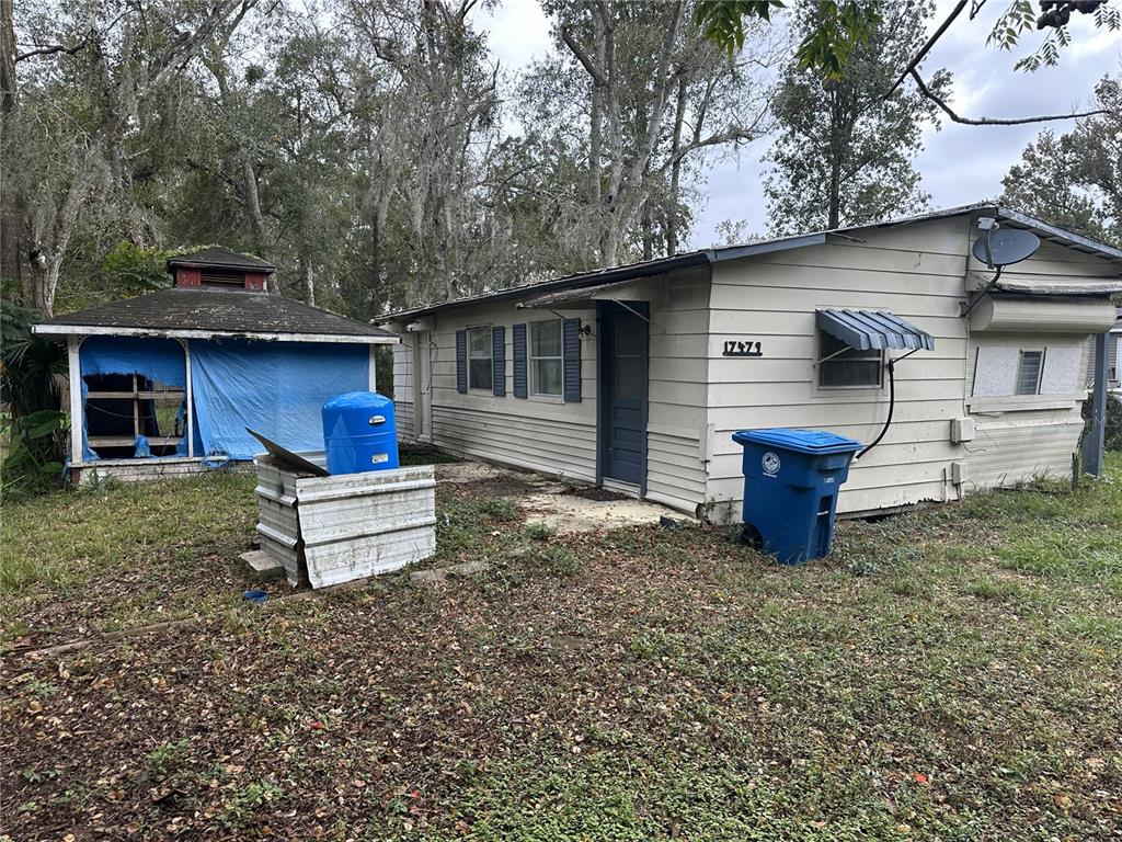17479 Tavern Road Brooksville, FL 34604 - Photo 3 of 10 a wooden bench sitting in front of a house