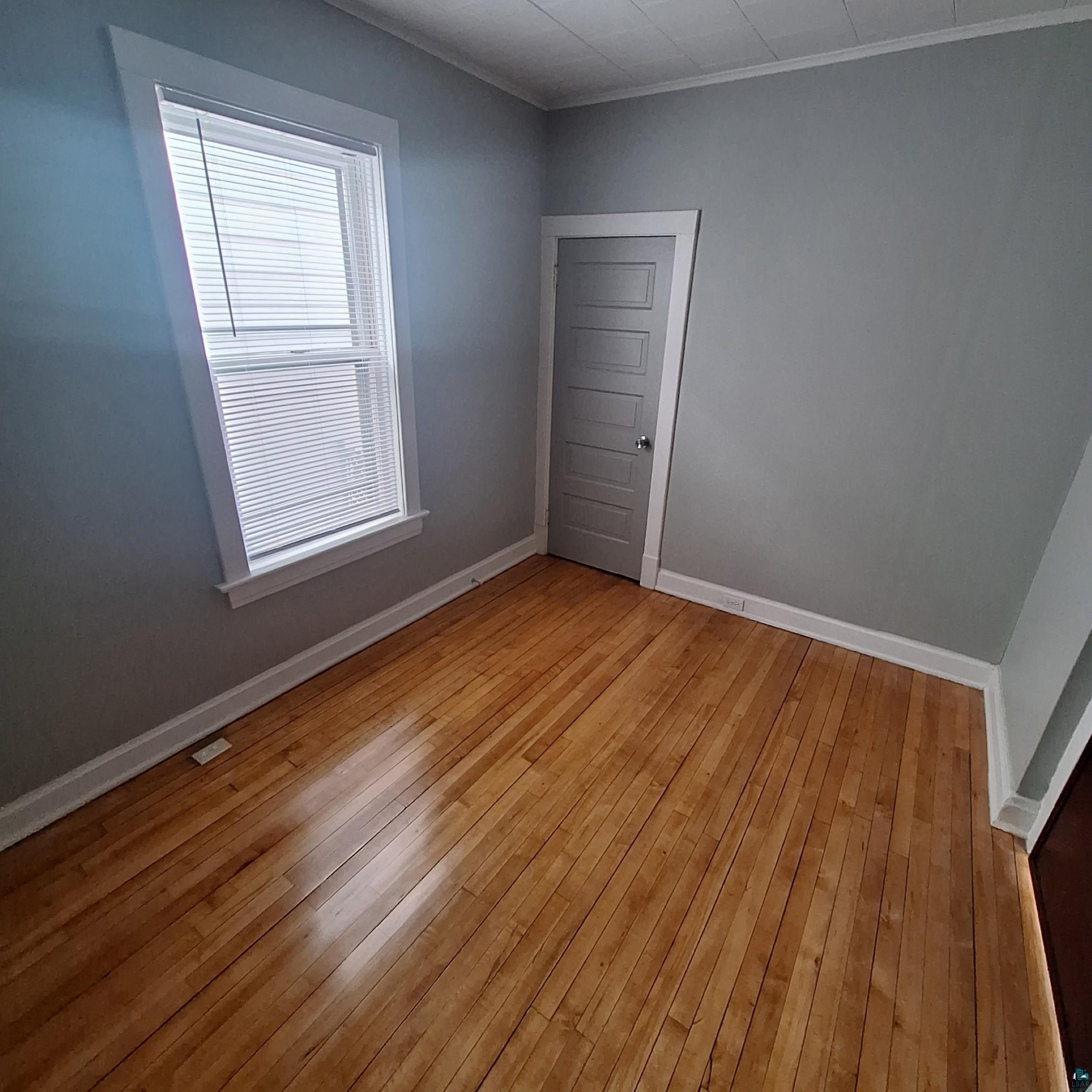 3141 Restormel Street Duluth, MN 55806 - Photo 12 of 13 Unfurnished room with light wood-style floors, baseboards, and ornamental molding