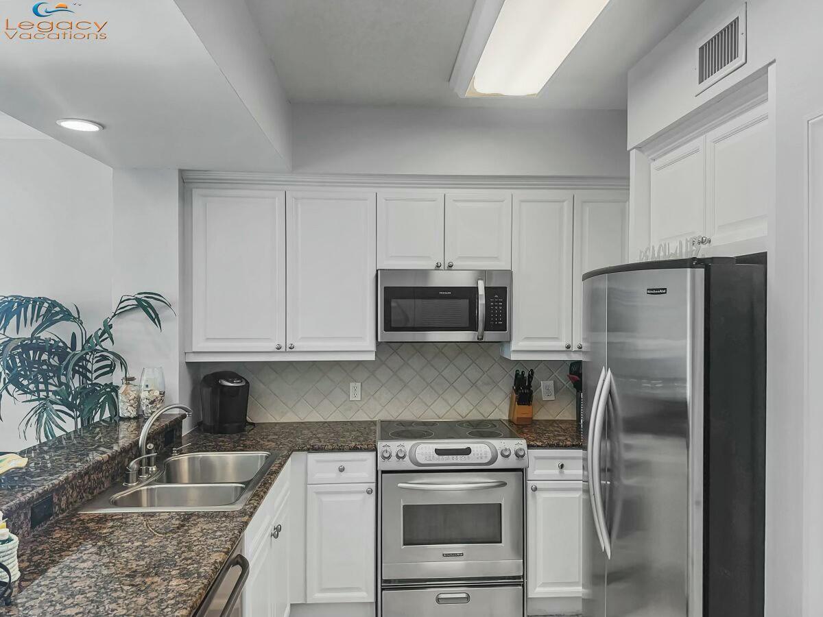 1150 Santa Rosa Boulevard, Unit 223 Fort Walton Beach, FL 32548 - Photo 13 of 53 a kitchen with granite countertop a refrigerator stove and microwave