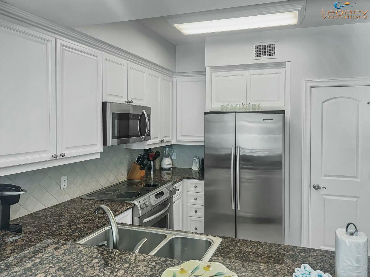 1150 Santa Rosa Boulevard, Unit 223 Fort Walton Beach, FL 32548 - Photo 14 of 53 a kitchen with a refrigerator sink and cabinets
