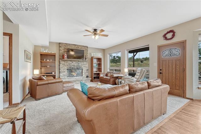 2690 Spaatz Road Monument, CO 80132 - Photo 10 of 50 Living room with light hardwood / wood-style floors, built in shelves, ceiling fan, and a fireplace