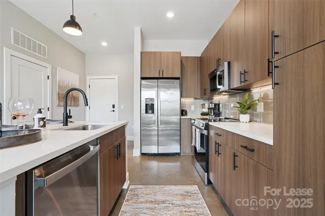 a kitchen with stainless steel appliances granite countertop a sink refrigerator and cabinets