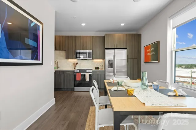 a kitchen with kitchen island a appliances wooden floor and a dining table