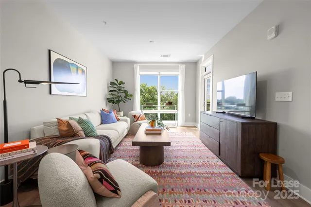 a living room with furniture large window and flat screen tv