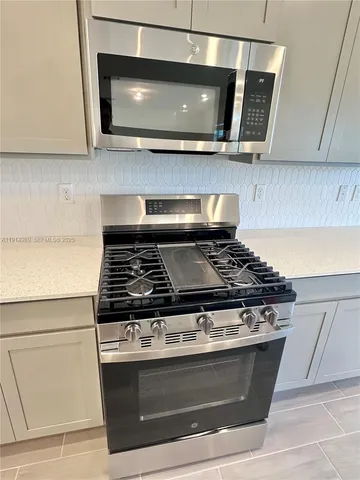 a stove top oven sitting inside of a kitchen