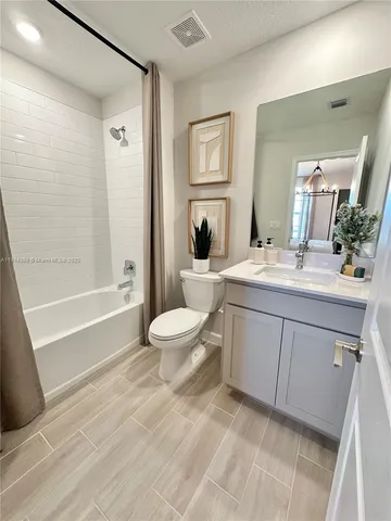 a bedroom with two beds and dresser next to a window