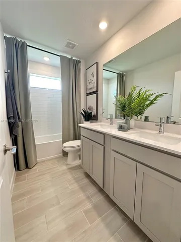 a bathroom with a double vanity sink toilet and shower